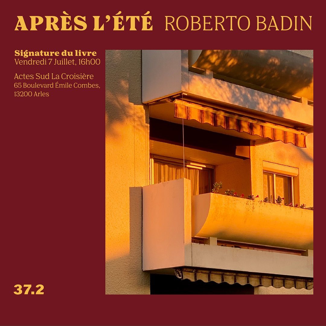 Building facade featuring balconies and windows bathed in warm, golden sunlight, creating a serene urban scene.