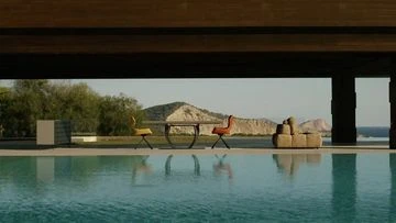 Outdoor living space with swimming pool overlooking the ocean and mountain, featuring modern outdoor furniture on the patio.
