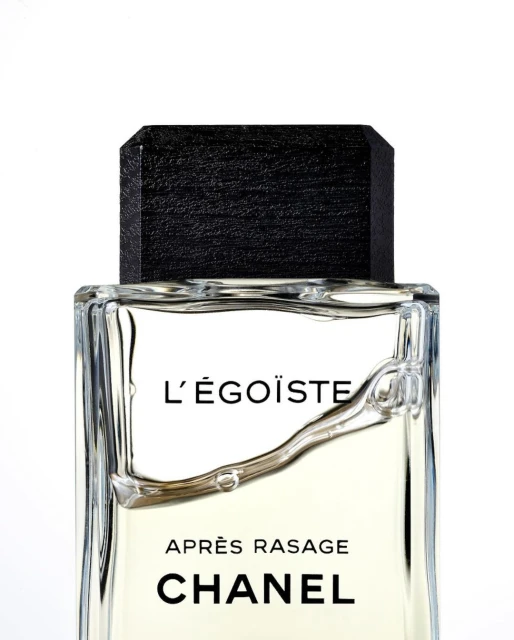 Close-up shot of Chanel L'Égoïste Après Rasage bottle with a black cap against a white background in a studio setting.