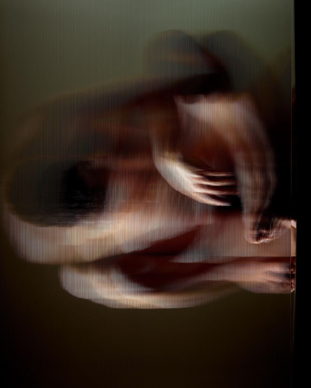 Abstract nude figure art with vertical striped overlay. Studio lighting illuminates the human form, creating soft shadows and textured skin.