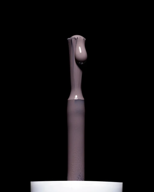 Close-up of a nail polish brush applicator with a droplet of mauve-colored nail polish against a dark black studio background.