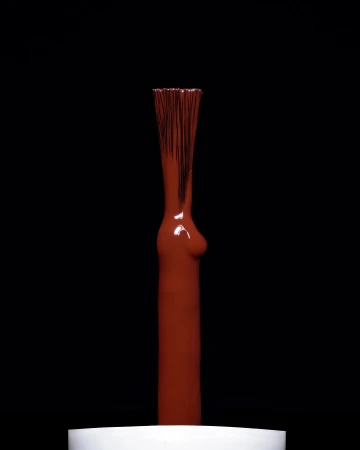 Close-up studio shot of a nail polish brush applicator with terracotta-brown, glossy liquid against a stark black background.