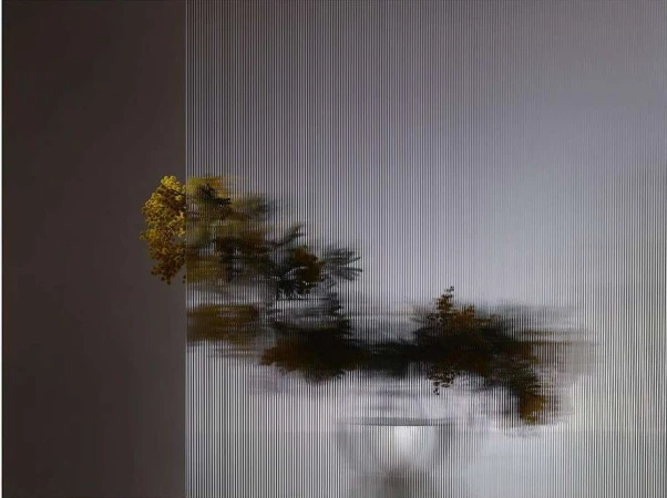 Still life photograph featuring yellow flowers in a vase, with an artistic striped effect creating a blurred and textured image.