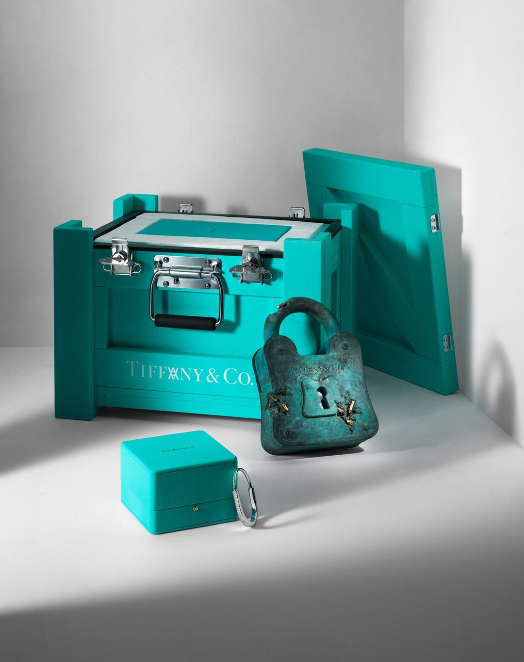 Tiffany & Co. wooden box set with a tarnished padlock on a white background, studio lighting, and product photography.