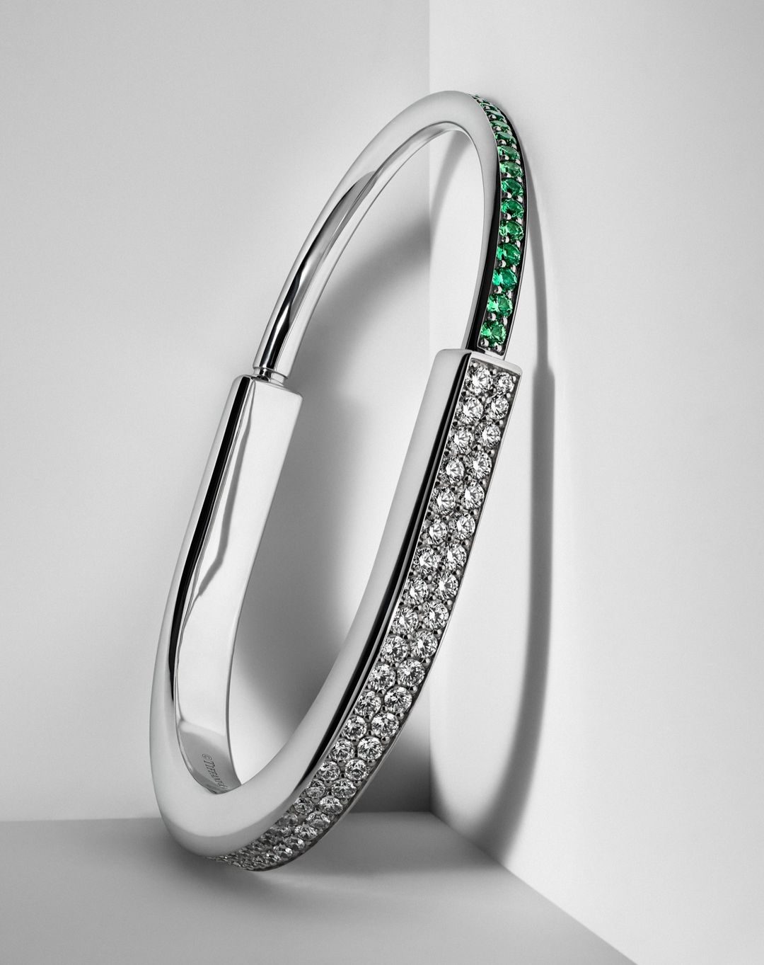 Elegant silver bracelet with green and white gemstones, displayed against a soft white background for a clean, luxurious aesthetic.