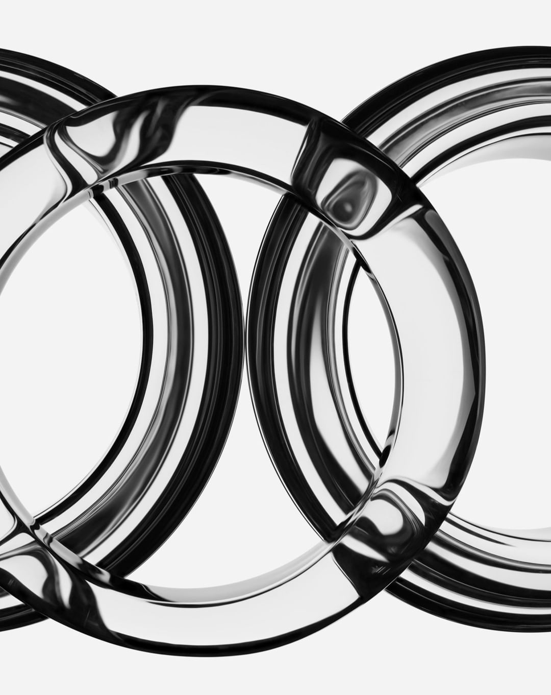 Close-up shot of three interlocking transparent rings overlapping each other, creating a visually interesting pattern on white background.