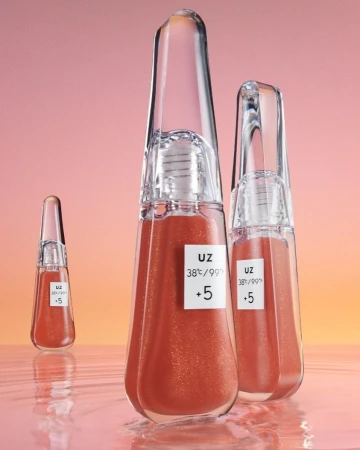 Three clear bottles of liquid makeup on a reflective surface, against a peach and yellow background, product photography.