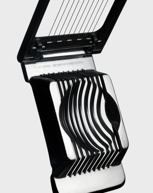 Close-up shot of a black and silver egg slicer, featuring a hinged design with wires for slicing, set against a neutral background.