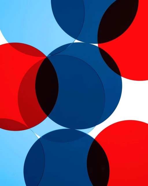 Overlapping geometric shapes, including semi-transparent red, blue, and light blue circles, create a vibrant abstract design on white.
