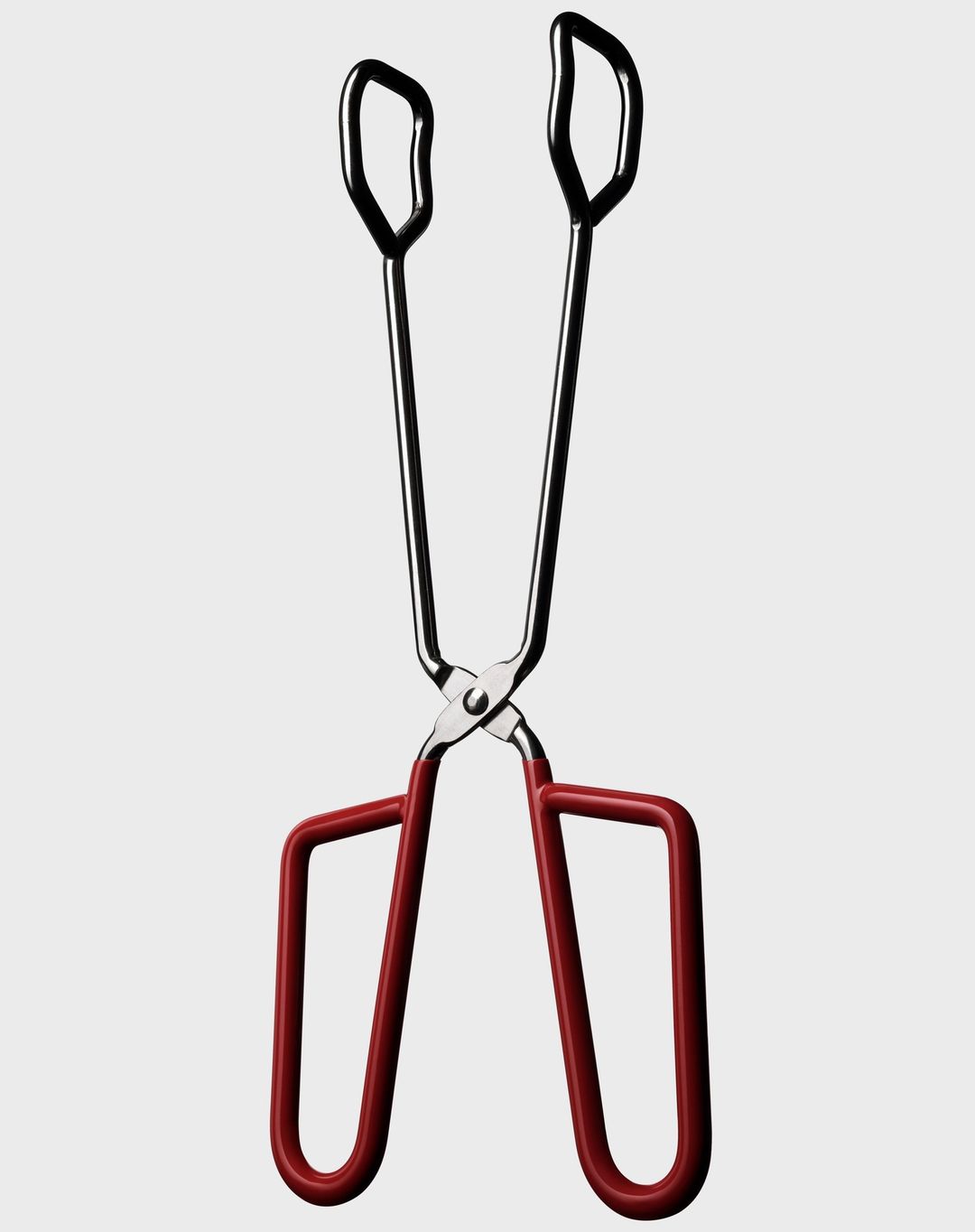 Silver and red cooking tongs on a white background, studio shot. Stainless steel construction. Kitchen utensil for grilling, serving, cooking.