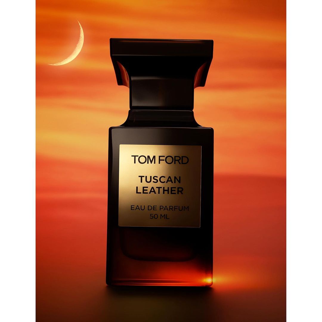 Tom Ford Tuscan Leather Eau de Parfum bottle on a gradient orange background with a moon, in a studio shot, showcasing the fragrance.