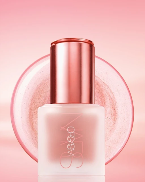 Close-up studio shot of a pink bottle of NARS Orgasm liquid blush with reflective accents and a matching pink background gradient.