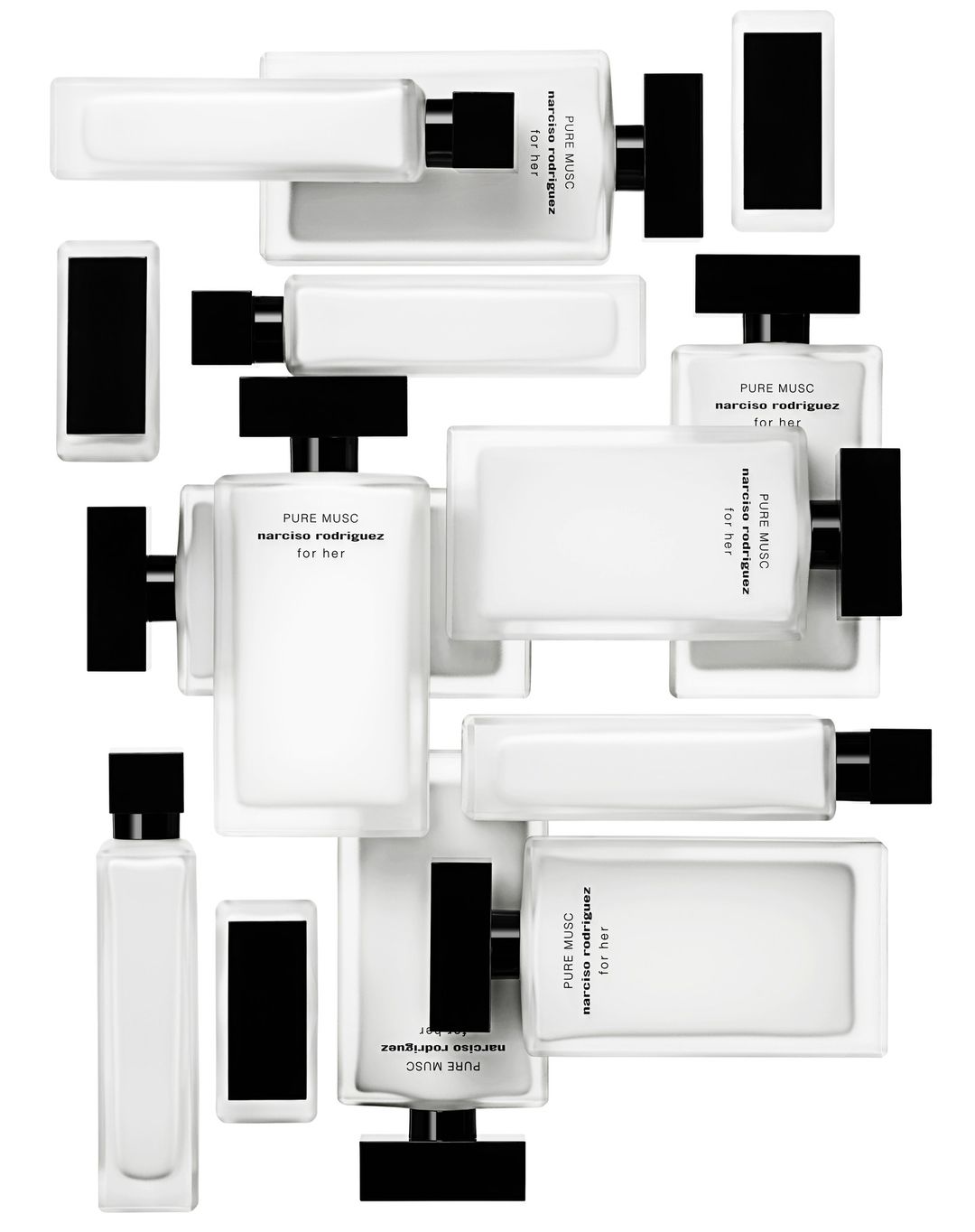 Multiple rectangular, white glass perfume bottles with black caps arranged at various angles on a white background. Close-up of fragrance products.