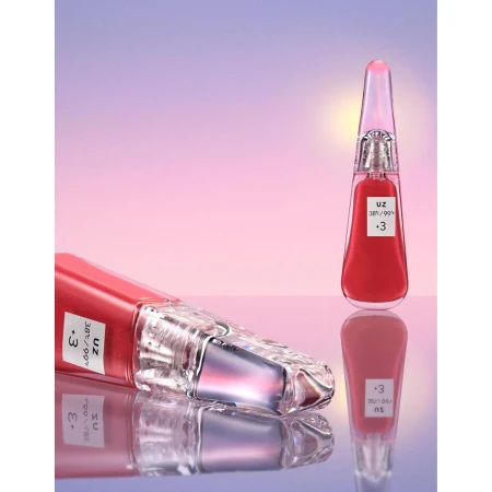 Product shot of two bottles of red lip gloss against a soft pink and purple gradient background with their reflections showing.