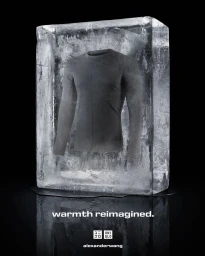 A grey long-sleeve thermal shirt frozen inside a large vertical block of clear ice on a dark reflective surface.