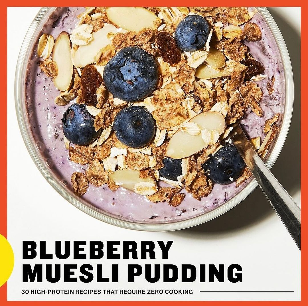 Overhead shot of a bowl filled with blueberry muesli pudding, topped with blueberries, almonds, and muesli for a healthy food recipe.