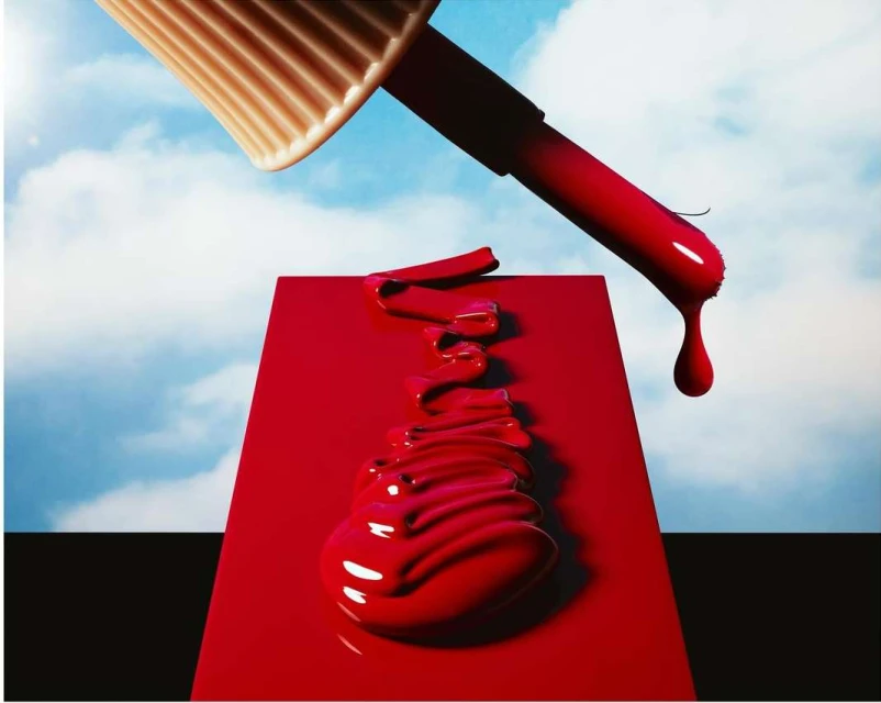 Striking beauty shot of red nail polish dripping from the brush onto a flat surface against a sky background, creating a vibrant, bold image.