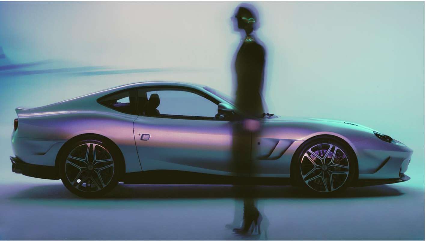 Sleek silver sports car showcased alongside a blurred figure, blending automotive design with fashion elements in a studio setting.
