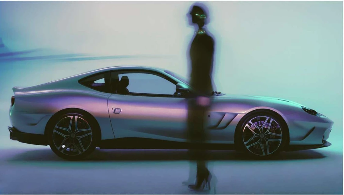 Sleek silver sports car showcased alongside a blurred figure, blending automotive design with fashion elements in a studio setting.
