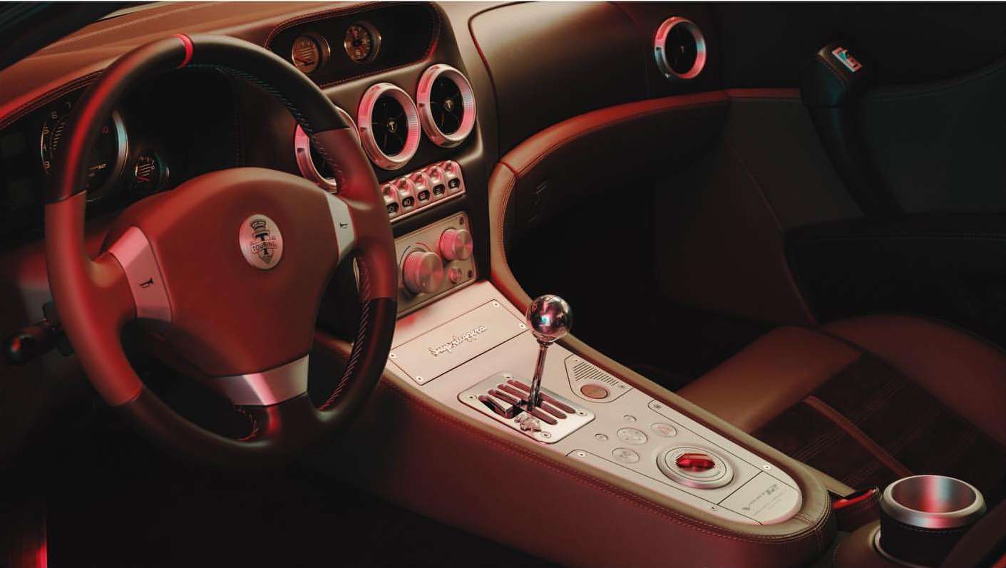 Interior view of a Spyker C8 Laviolette with brown leather and metal details, featuring a gear shift, steering wheel, and dashboard.