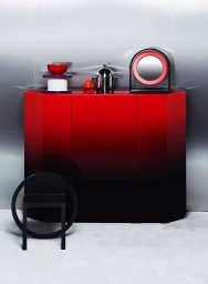 Red and black gradient cabinet with minimalist decorative objects photographed by Romain Roucoules in Paris