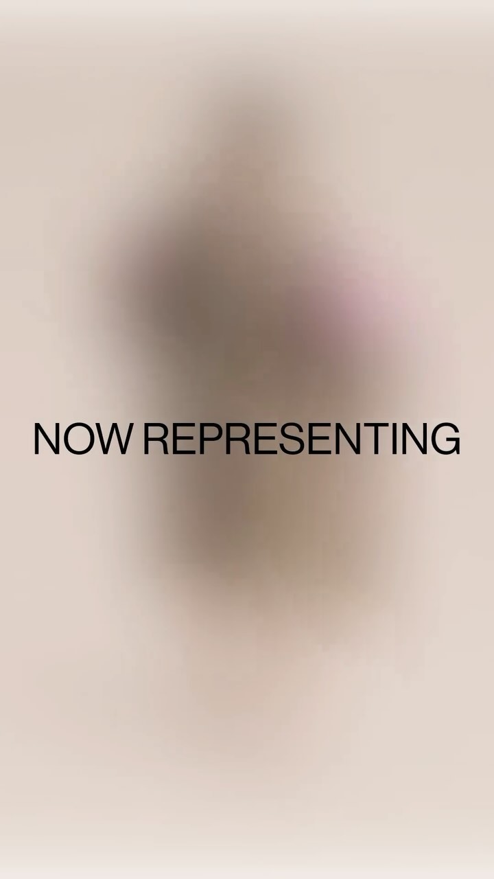 Blurred figure centered against a pale tan background, overlaid with the black text 'NOW REPRESENTING'. Abstract and minimal.