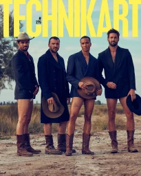 Four men in blazers and cowboy boots posing outdoors on a dirt path with hats, photographed by Romin Favre.