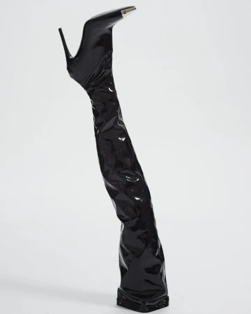 Elevated view of a single, shiny black stiletto-heeled thigh high boot with a silver tip on a white seamless background.