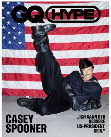 Casey Spooner lies in front of US flag wearing a sailor suit, leather gloves, and boots on the cover of GQ Hype magazine.