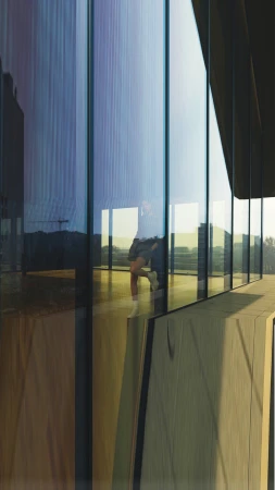 Adult is reflected in building's glass exterior with the city buildings in the background, in an urban setting, during daytime.