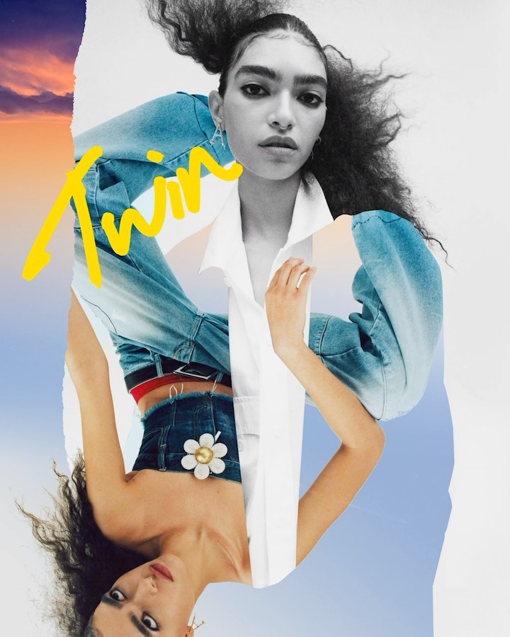 Fashion editorial featuring a woman with curly dark hair wearing light-wash denim and a white shirt, with a sky and sunset background.