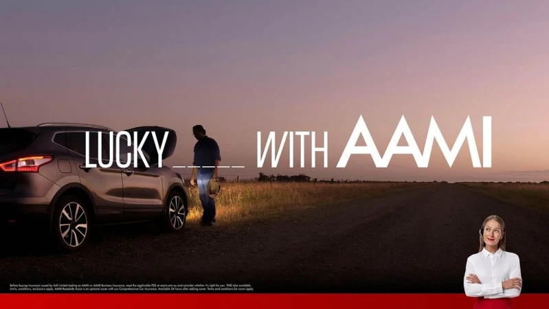 Car parked on a rural road at sunset with an adult male near the open trunk, and a customer service representative on lower-right.