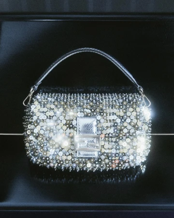 Fendi Baguette handbag with a silver handle and embellished with silver sequins and pearl beads against a dark glossy background.