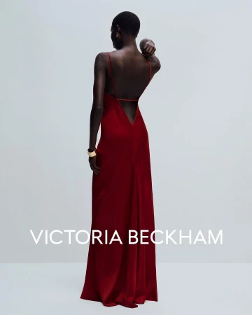 Model wearing a backless red silk slip dress photographed from behind against a plain white studio background.