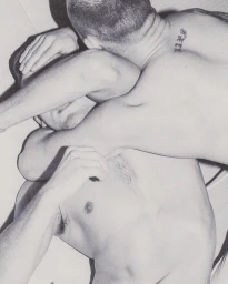 Close-up black and white photograph of two men wrestling and grappling, captured in grainy high contrast by Rosie Harriet Ellis.