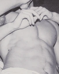 Monochrome close-up of a man's shirtless torso and hands resting on his chest, photographed by Rosie Harriet Ellis.