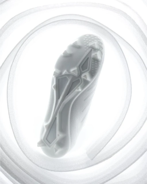 A close-up, high-angle shot captures the sole of a white athletic shoe surrounded by a spiraling white ribbon on a bright background.
