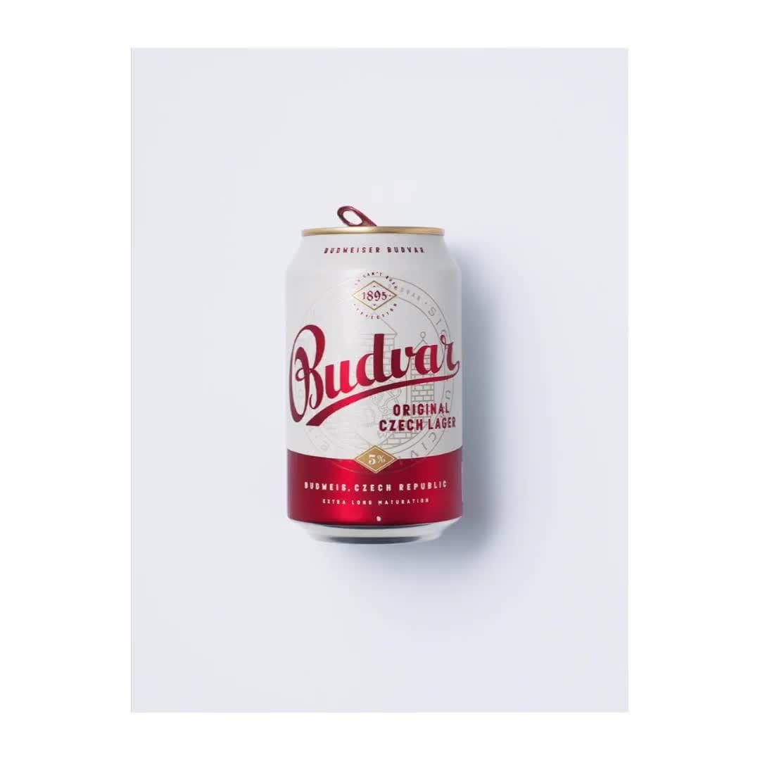 Studio shot of a white aluminum can of Budvar Original Czech Lager, featuring red and gold accents, placed on a clean white background.