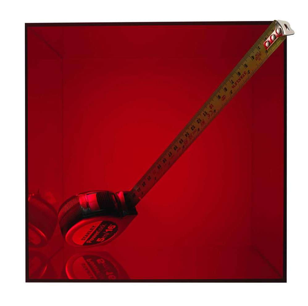 A metallic Stanley Powerlock measuring tape with black and yellow housing is extended against a vibrant red backdrop. Construction tool.