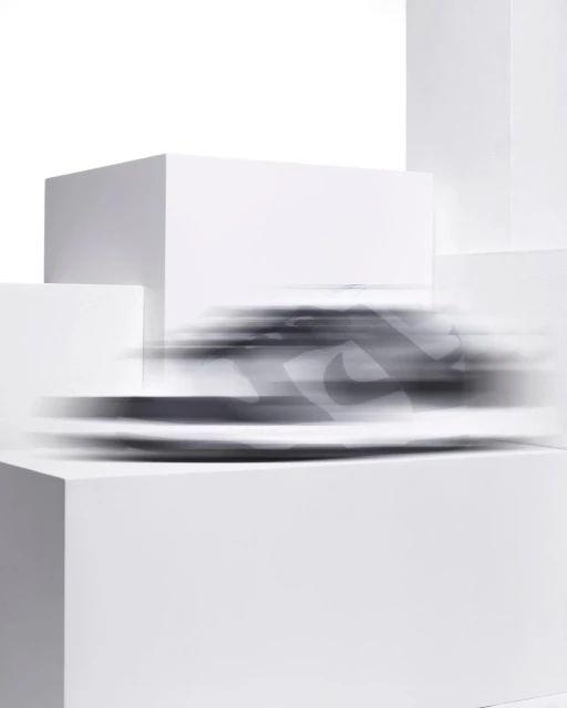 Dynamic studio shot of a blurred athletic shoe with a white background, placed on a stepped white cube platform, promoting motion and speed.