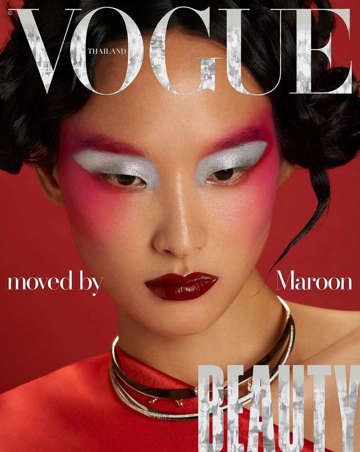 Vogue Thailand cover featuring a model with bold magenta and silver eyeshadow, dark red lipstick, wearing a silver choker, on a red background.