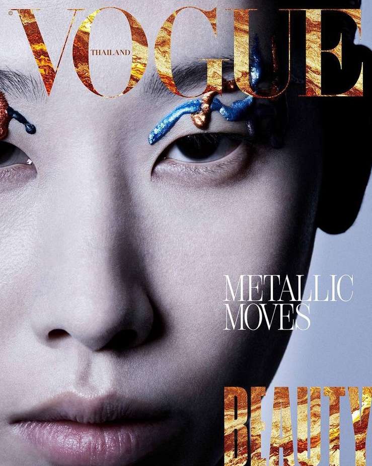 Vogue Thailand cover featuring a close-up of a woman with artistic blue and gold makeup around her eyes, overlaid with gold foil text.