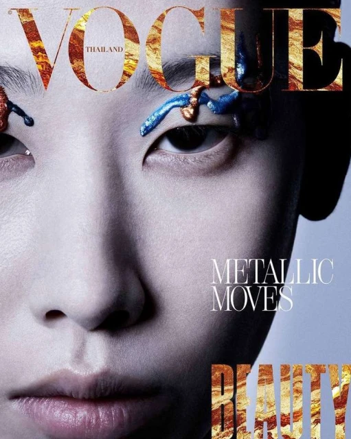 Vogue Thailand cover featuring a close-up of a woman with artistic blue and gold makeup around her eyes, overlaid with gold foil text.