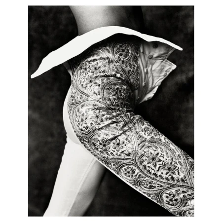 Close-up of a matador in costume featuring a heavily embroidered jacket with silver accents. The image has a monochromatic tone.