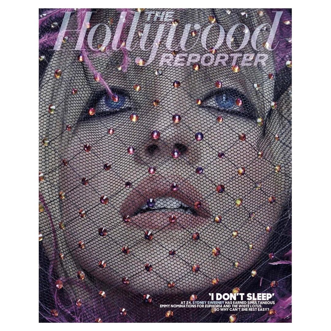 Close-up of a woman's face wearing a mesh head covering with pink jewels, featured on the cover of The Hollywood Reporter magazine.