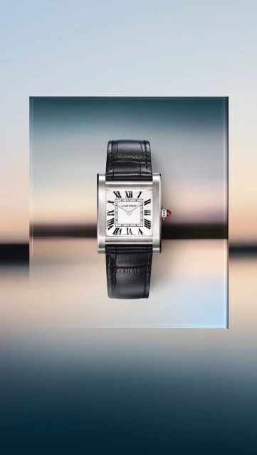 Silver Cartier Tank watch with black leather strap on a reflective surface against a gradient background. Luxury timepiece advertisement.
