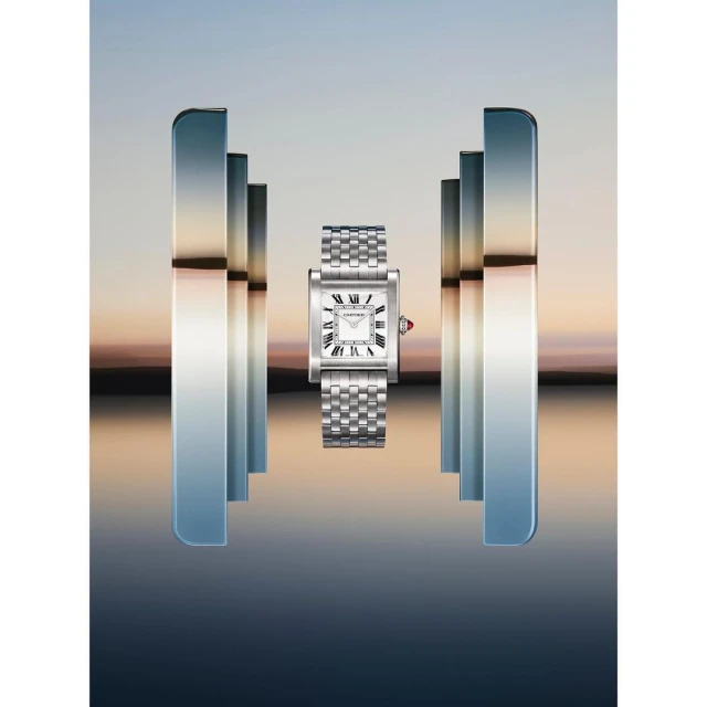 Elegant, silver Cartier Tank watch with a white face, floating between mirrored pillars on a reflective, blurred background, timekeeping precision.