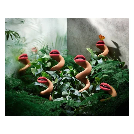 Surreal plant-like serpentine sculptures with human-like red lips emerging from lush green foliage and moss.