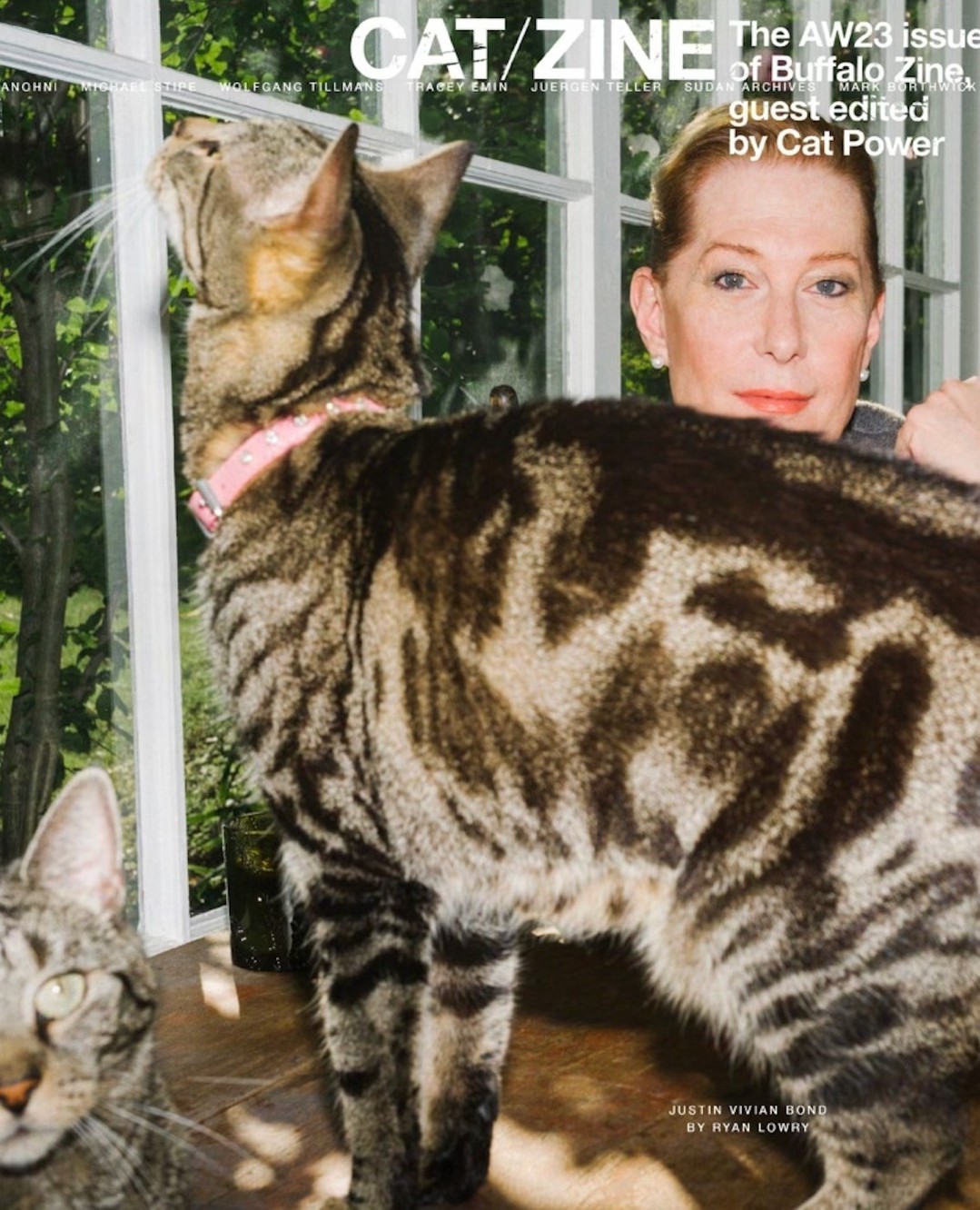 Magazine cover featuring a woman posing with two cats, one wearing a pink collar, with a window and greenery visible in the background.