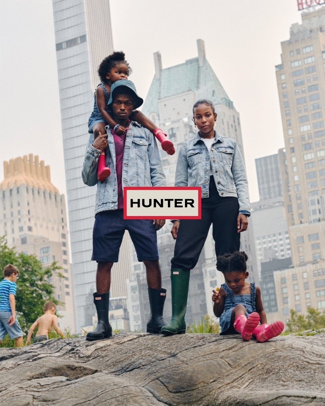 Hunter brand campaign featuring a group of African-descent people, including children, wearing rain boots in an urban setting.